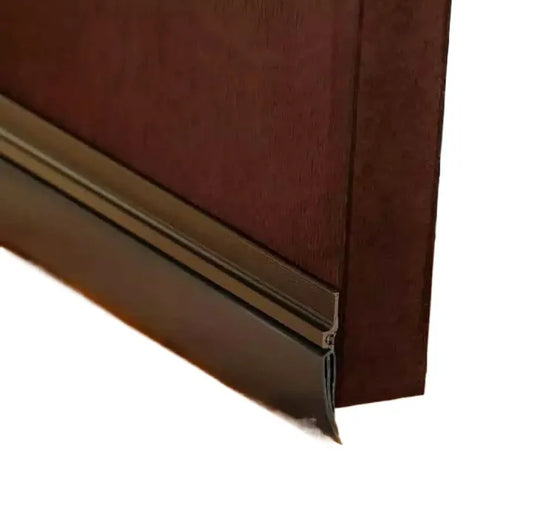 Brown aluminum door bottom seal with black rubber for soundproofing and weatherproofing.