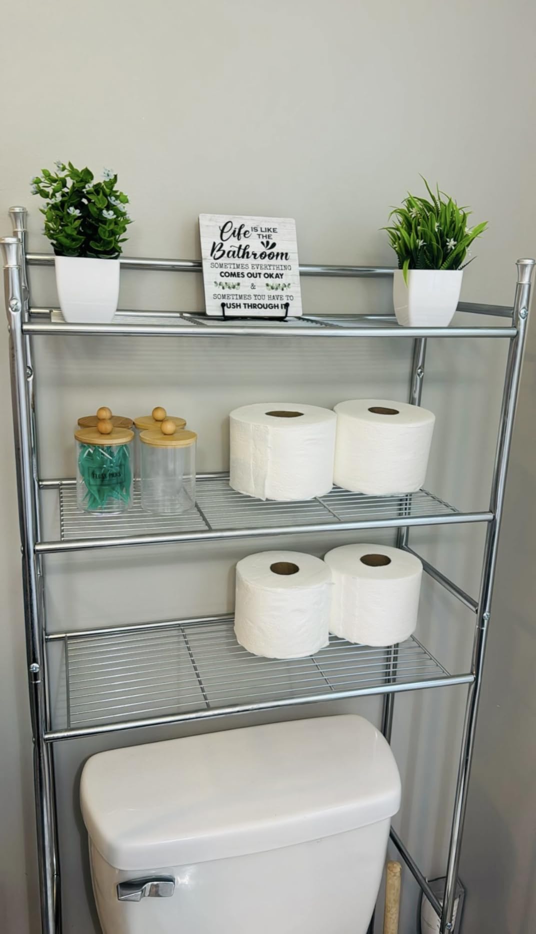 Sleek over-the-toilet storage rack with multiple shelves, ideal for organizing towels and toiletries in a modern bathroom.