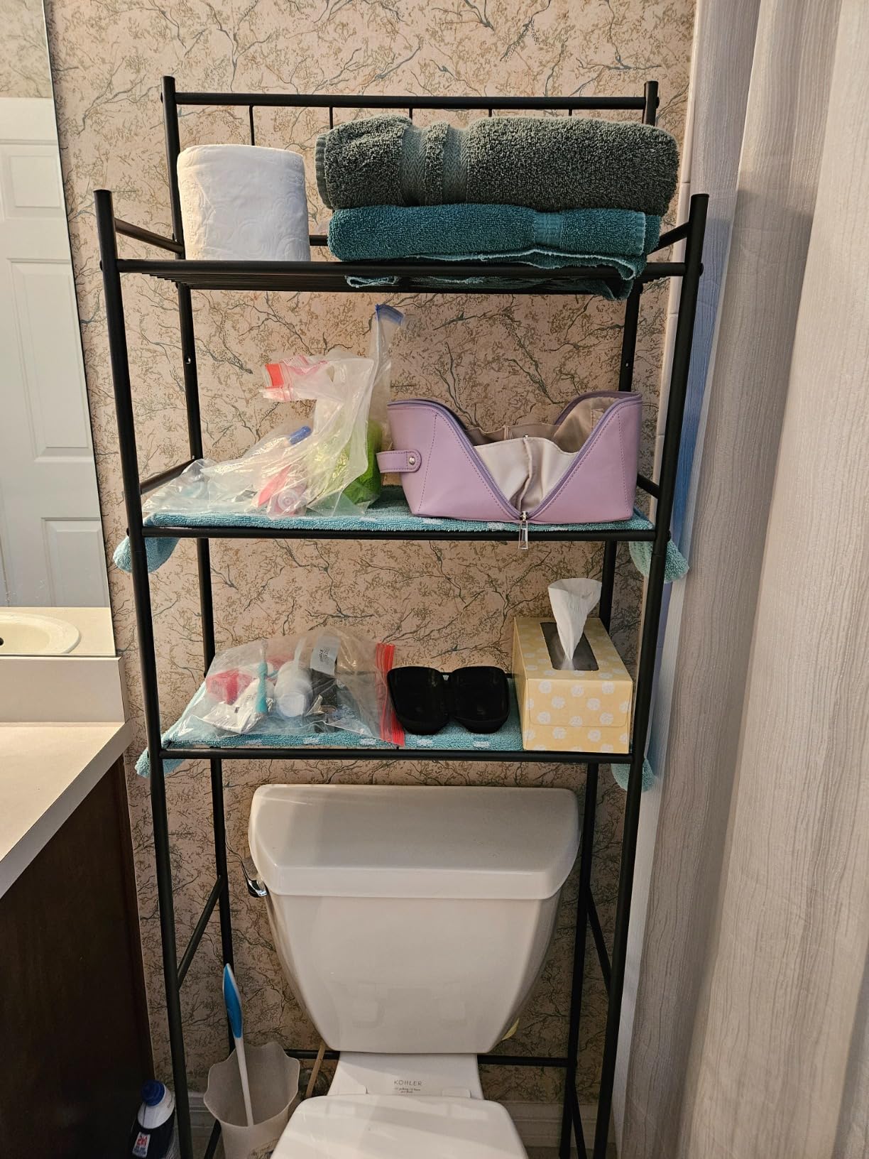 Sleek over-the-toilet storage rack with multiple shelves, ideal for organizing towels and toiletries in a modern bathroom.