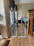 Adjustable baby gate installed in a doorway to keep the baby safe