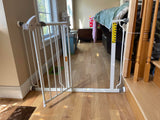 Adjustable baby gate installed in a doorway to keep the baby safe