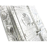 Ornate silver metal Quran holder with an elegant design.