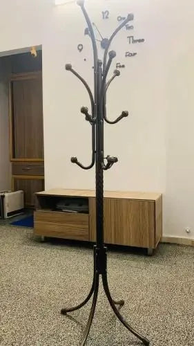 Height-adjustable steel coat hanger stand with rust-resistant silver chrome finish.