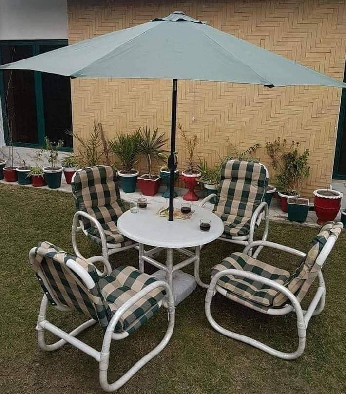 Waterproof garden chair set featuring 4 chairs, 1 table, and 1 umbrella, made from durable PVC-coated fabric for all-weather use.